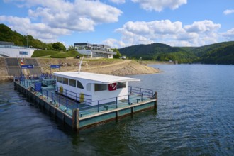 Jetty with small boat on a lake under blue sky with clouds, summer, Rursee, Obersee, Rurberg,