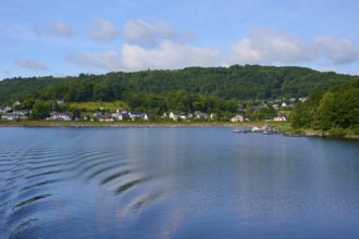View across the lake to a village with hills in the background, Rursee, Rurberg, Simmerath, Eifel