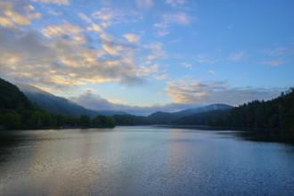 Gentle morning colour reflected on the quiet lake, surrounded by hills and clouds, summer, Rursee,