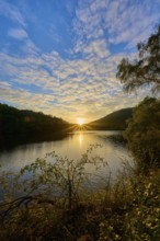 Sunset over a lake, dramatic cloud formations and golden light on the water, summer, Rursee,