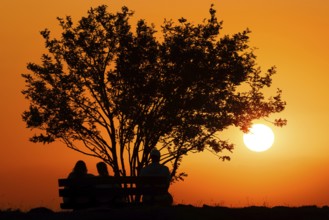 People watching the sun set on the horizon from the summit of the GroÃŸer Feldberg in the Taunus,