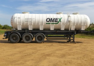 Omex fertiliser road tanker container waggon standing in field, Alderton, Suffolk, England, UK