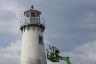 Detroit, Michigan - A worker on a lift paints the Milliken State Park Lighthouse. The lighthouse is
