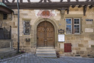 Detailed view of a historic half-timbered house with an ornate, double-leaf wooden door, Kessler