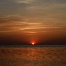 Fireball... Sunset over the Wadden Sea near Duhnen, Cuxhaven, North Sea, glowing red setting sun,