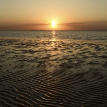 Sunset over the Wadden Sea on the German North Sea coast, low sun over Neuwerk, typical ripple