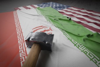 Large hammer resting on american and Iranian flags