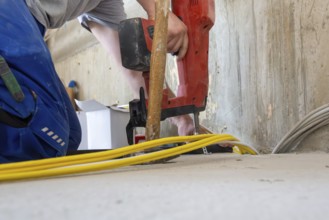 Electrical installation on the building shell: Installer lays cables
