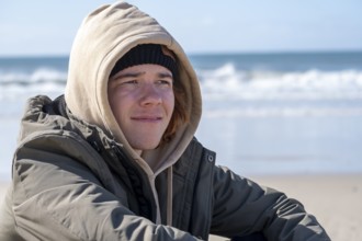 Young man with red hair, sitting on the beach, Jeffreys Bay near Port Elizabeth, Garden Route,