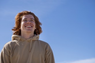 Young man red-haired, laughing, against blue sky, Jeffreys Bay near Port Elizabeth, Garden Route,