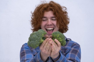 Young man, happy about broccoli, vegetables, kitchen food, Bavaria, Germany