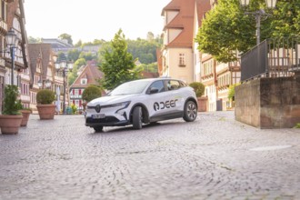 Renault drives through a picturesque town with cobblestones, Deer E, car sharing, electric car,
