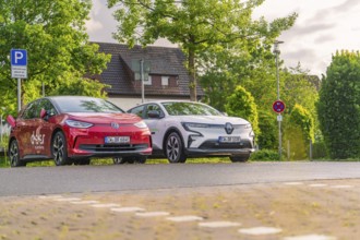 Two electric cars parked under trees in a quiet residential street, Deer E, car sharing, electric