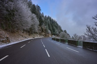 Snowy road snaking through a wintery forest with frost-covered trees, winter, Col de la Schlucht,
