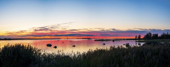 Colourful sunset over a calm lake with clouds, peaceful atmosphere, Svedjehamn, Kvarken