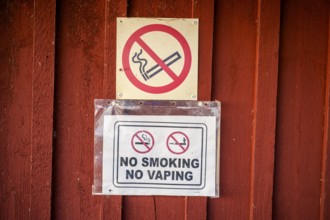 Red wall with no smoking signs prohibiting smoking and vaping, Svedjehamn, Kvarken Archipelago,
