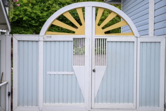 Street scene in the old town of Naantali, a decorative wooden gate in pastel shades with a