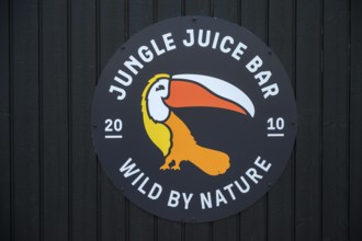 Street scene in the old town of Naantali, A jungle juice bar tropical logo with a toucan on a dark