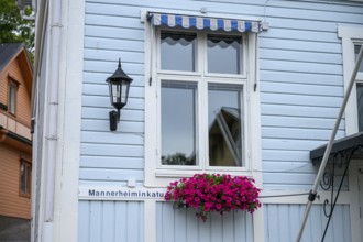 Street scene in the old town of Naantali, light blue wooden house with white windows and blooming