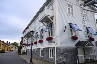 Large historic building with balconies and blooming flowers, on a quiet street in the old town,