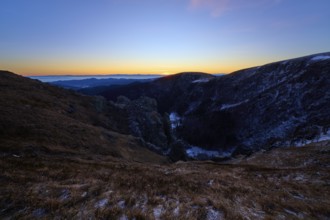 First rays of light over mountain peaks, cool morning with purple sky, view of the Rhine Valley,