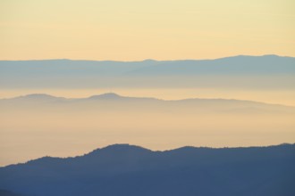 Gentle mountain silhouettes in morning haze with warm sunlight, looking towards the Rhine Valley,