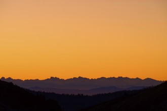 Mountain silhouette at sunrise with orange sky, looking at Alps, Hohneck, La Bresse, Vosges, France