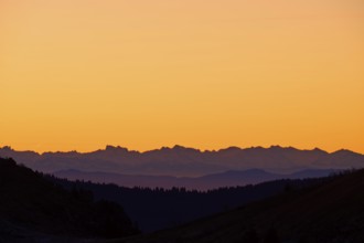 Silhouette of mountains at sunrise with orange sky, looking at Alps, Hohneck, La Bresse, Vosges,