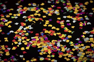 Colorful confetti on black background, carnival
