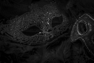 Black masks on a dark background, contrasting carnival atmosphere