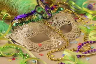 Golden carnival mask, colorful beads and confetti, carnival