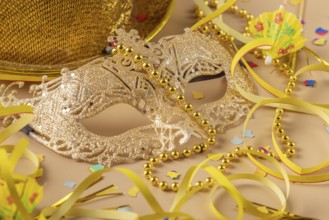 Golden mask with pearls surrounded by carnival decoration