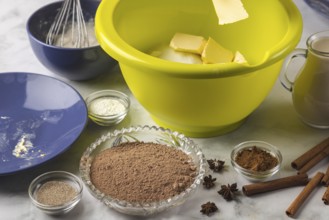 Butter is added to dough bowl surrounded by baking ingredients