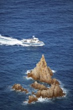 Visitors on an excursion boat look at bizarre rock formations at Capo Rosso, Piana, Corse-du-Sud