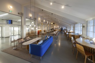 A 1950s style restaurant with seating, tables, large windows and hanging lamps, Olympic Stadium,