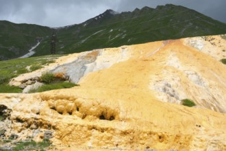 Yellow rocky landscape with green mountains and dark cloudy sky, Bidara Travertine, Travertine,