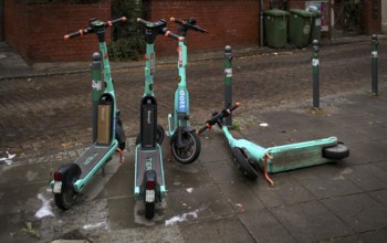 E-scooters, electric scooters, scooters parked and carelessly left lying on the side of the road in