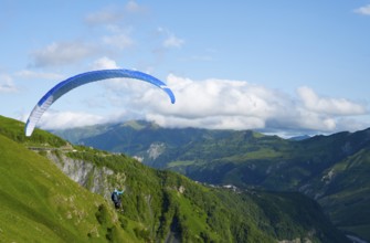 Paraglider flying with blue sky and mountain scenery, a sense of freedom and adventure, paraglider,