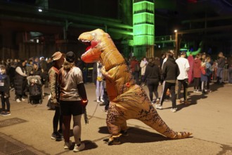 Person in inflatable dinosaur costume at Halloween Run, night run in the Duisburg-Nord Landscape