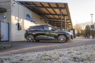 Car parked in a frosty parking lot in front of an outdoor pool building early in the morning, MG4