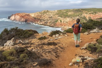 Hiking woman, view over cliff, Fishermens Trail, Rosa Vicentina, western Algarve just north of cape