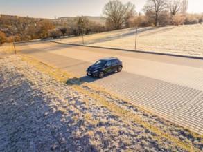 Car parked on a sunny street in a wintry landscape, MG4 electric car, deer e-car sharing, Calw,