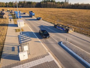 Several vehicles in a parking lot on a country road on a sunny autumn day, MG4 electric car, Deer