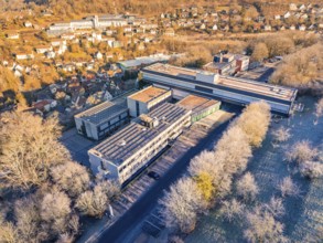 Aerial view of a large building complex surrounded by trees in an autumn landscape, MG4 electric
