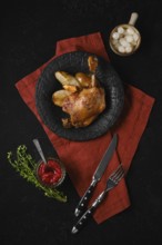 A plate holds a portion of duck confit alongside roasted pears. A small bowl of lingonberry sauce