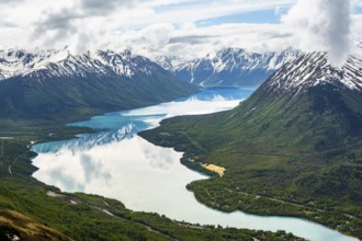 View of snowy mountains in spring and turquoise Kenai Lake with reflection, Slaughter Ridge Trail,