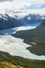 View of snowy mountains in spring and turquoise Kenai Lake with reflection, Slaughter Ridge Trail,