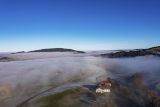 Drone view, agricultural landscape with farmhouse in autumnal morning fog, inversion weather,