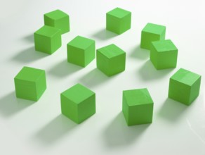 11 green wooden cubes against a white background