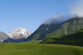 Hilly landscape with snow-capped peaks and clouds, landscape between Kvesheti and Gudauri,